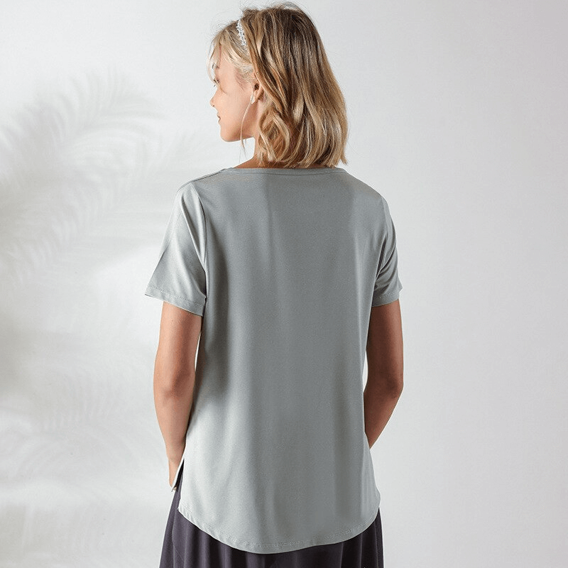 Back view of a woman wearing a gray loose hollow out shoulders t-shirt for running, showing breathable fabric and relaxed fit.